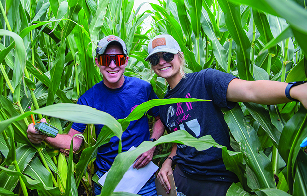 Ag students in a cornfield smiling at the camera